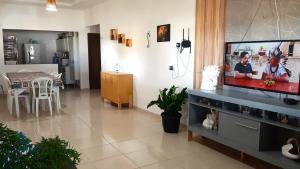 ein Wohnzimmer mit einem Flachbildfernseher auf einem Entertainment-Center in der Unterkunft Casa de Praia Toca da Onça in São Miguel do Gostoso