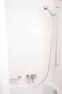 a shower in a white bathroom with a tub at Armotti Weissenbühl 1 Bedroom Apartment in Bern