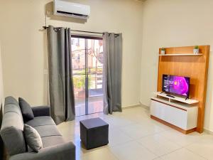a living room with a couch and a tv at Departamento cerca de todo en Cde in Ciudad del Este