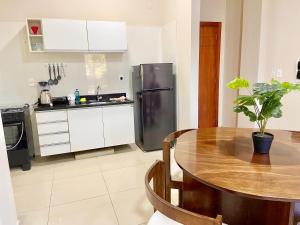 a kitchen with a table and a stainless steel refrigerator at Departamento cerca de todo en Cde in Ciudad del Este