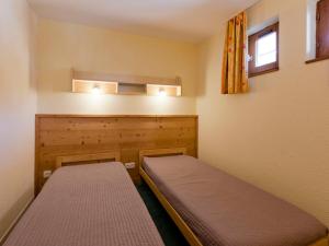 a small bedroom with two beds in it at Duplex skis aux pieds 9 pers, parking inclus - FR-1-513-8 in La Tania