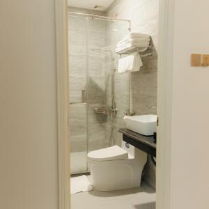 a bathroom with a shower and a toilet and a sink at Lucky Hotel in Bạc Liêu