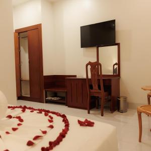 a room with a desk and a bed with roses on the floor at Lucky Hotel in Bạc Liêu +18 photos