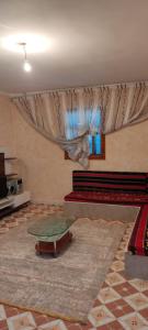 a living room with a glass table and a curtain at appartement à louer Djerba in Al Maqārisah