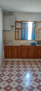 a kitchen with a checkered floor in a room at appartement à louer Djerba in Al Maqārisah +10 photos