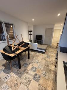 a living room with a table and chairs on a tile floor at Grand T4 lumineux proche du lac de Molières in Molières