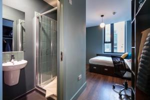 un bagno con lavandino e doccia e un letto di Copley Court a Cork