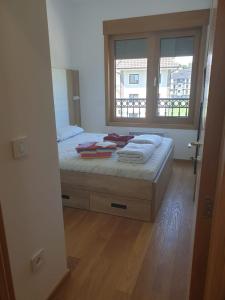 a bedroom with a bed with a window and a window at Vila Elsa in Zlatibor
