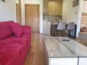 a living room with a purple couch and a kitchen at Vila Elsa in Zlatibor +3 photos