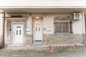 a house with two white doors and a gate at Mary's Downtown Home - a stroll away from Mount Vermio in Naousa Imathias