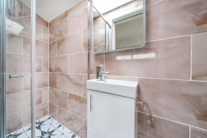 a bathroom with a sink and a shower at Cottage in the heart of award-winning English village in Woodchurch