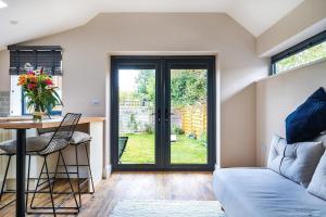 a living room with a couch and a table at Cottage in the heart of award-winning English village in Woodchurch +10 photos