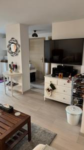 a living room with a white dresser and a table at Red Stone Apartman Kővágóörs Pálköve 200m a Balaton parttól kilátással in Kővágóörs