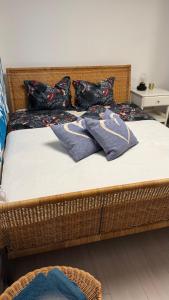a wicker bed with pillows on top of it at Red Stone Apartman Kővágóörs Pálköve 200m a Balaton parttól kilátással in Kővágóörs