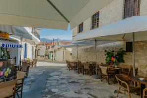 an outdoor patio with tables and chairs and umbrellas at Rustic Elegance in Omodos in Omodos