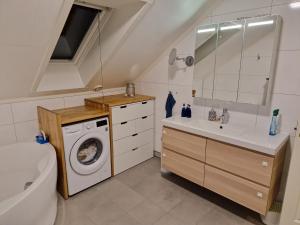a bathroom with a washing machine and a sink at Granåsen World Championship Stay Walk to Ski Arena in Trondheim +22 photos