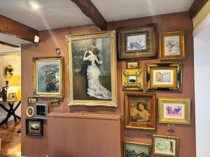 a wall with a bunch of paintings on it at WestLaigh Lrg Luxury Country Farm House 20 min from the city in Glassford