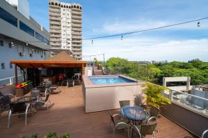 a balcony with chairs and a swimming pool on a building at Tarobá Hotel in Foz do Iguaçu