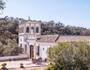 un grande edificio bianco con una torre dell'orologio di Finca Rural Los Gorriones a El Garrobo