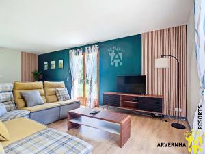 a living room with a couch and a tv at Villa Clara in Murol