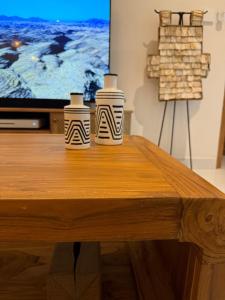 deux vases assis sur une table en bois devant une télévision dans l'établissement Amazing rice field-view Villa 3min walk to the sea, à Munggu 32 autres photos