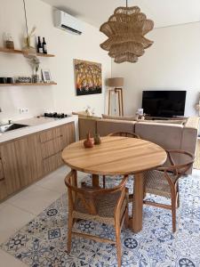 Il dispose d'une cuisine et d'un salon avec une table et des chaises en bois. dans l'établissement Amazing rice field-view Villa 3min walk to the sea, à Munggu