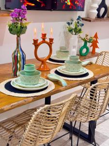 einem Holztisch mit Tellern und Kerzen darauf in der Unterkunft Appartement luxe au cœur de Marrakech in Marrakesch