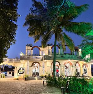 a building with a palm tree in front of it at Jaladarshini Lakeside Gardens in Kollam +18 photos