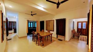 a dining room with a wooden table and chairs at Ambady Plantation Residency in Thekkady