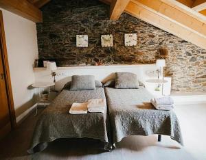 a bedroom with two beds and a stone wall at Casa Guillem Completa in Tavascan