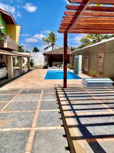 a house with a patio and a swimming pool at Residência Lençóis Pousada in Barreirinhas