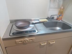a kitchen with a sink and a frying pan on a stove at プロスパー泉30 in Nagoya
