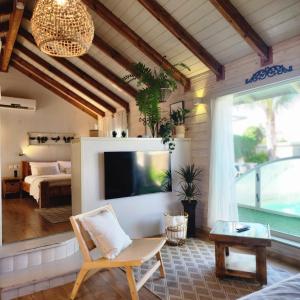 a living room with a television and a bedroom at ברוגע אצל נוגה סוויטה עם בריכה פרטית in Moshav Ramot