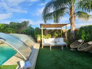 a garden with a gazebo and a swimming pool at ברוגע אצל נוגה סוויטה עם בריכה פרטית in Moshav Ramot