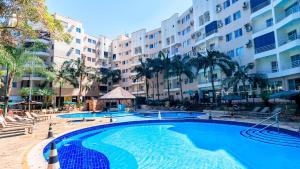 a large swimming pool in front of a building at Thermas Paradise Apartamentos Rio Quente Esplanada in Rio Quente