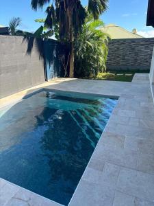 a swimming pool with blue water in a backyard at Saka Lodge in Le Gosier