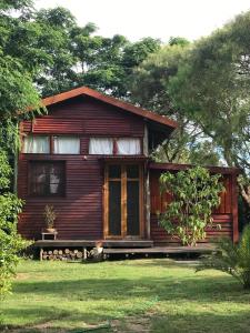 a small wooden house in a yard with grass at Cabaña de madera para 4 personas in Playa Hermosa