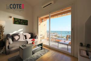 a living room with a couch and a view of the ocean at L'Espéron in Sausset-les-Pins