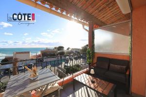 a balcony with a couch and a view of the ocean at L'Espéron in Sausset-les-Pins