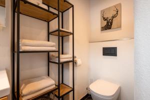 a bathroom with a toilet and a towel rack at Alpenblick in Brixen im Thale +28 photos