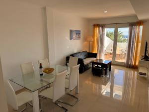 a living room with a glass table and chairs at Heavenly Homes Mojacar 73 in Mojácar