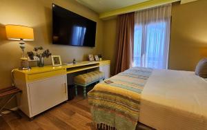 a hotel room with a bed and a desk with a television at HOTEL KONKE MAR DEL PLATA in Mar del Plata