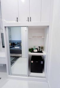 タナ・メラにあるAuranad TinyHouse bandar Tanah Merah Wifi Netflixの白い戸棚(ベッド付)