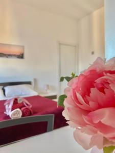 una camera con un letto di fiori rosa di L 'APPRODO FELICE a Palermo