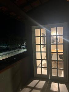 a room with an open door with a table and a window at Casa estilosa na rua principal de Búzios in Búzios +8 photos