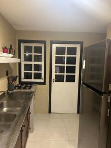 a kitchen with a sink and a refrigerator at Casa estilosa na rua principal de Búzios in Búzios