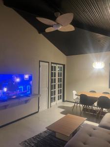 a living room with a table and a tv at Casa estilosa na rua principal de Búzios in Búzios