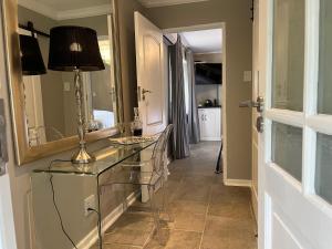 a bathroom with a table with a lamp and a mirror at Patcham Place, Clarens in Clarens +77 photos