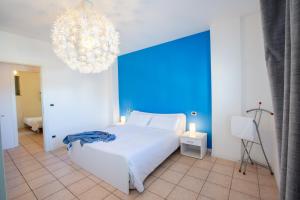 a bedroom with a white bed and a chandelier at Casa Adelaide - Vicino al mare, al centro, terrazza con vista in Senigallia