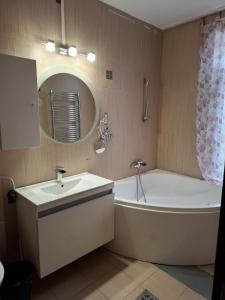 a bathroom with a sink and a tub and a mirror at Motel DHS - Chinese Restaurant in Deva